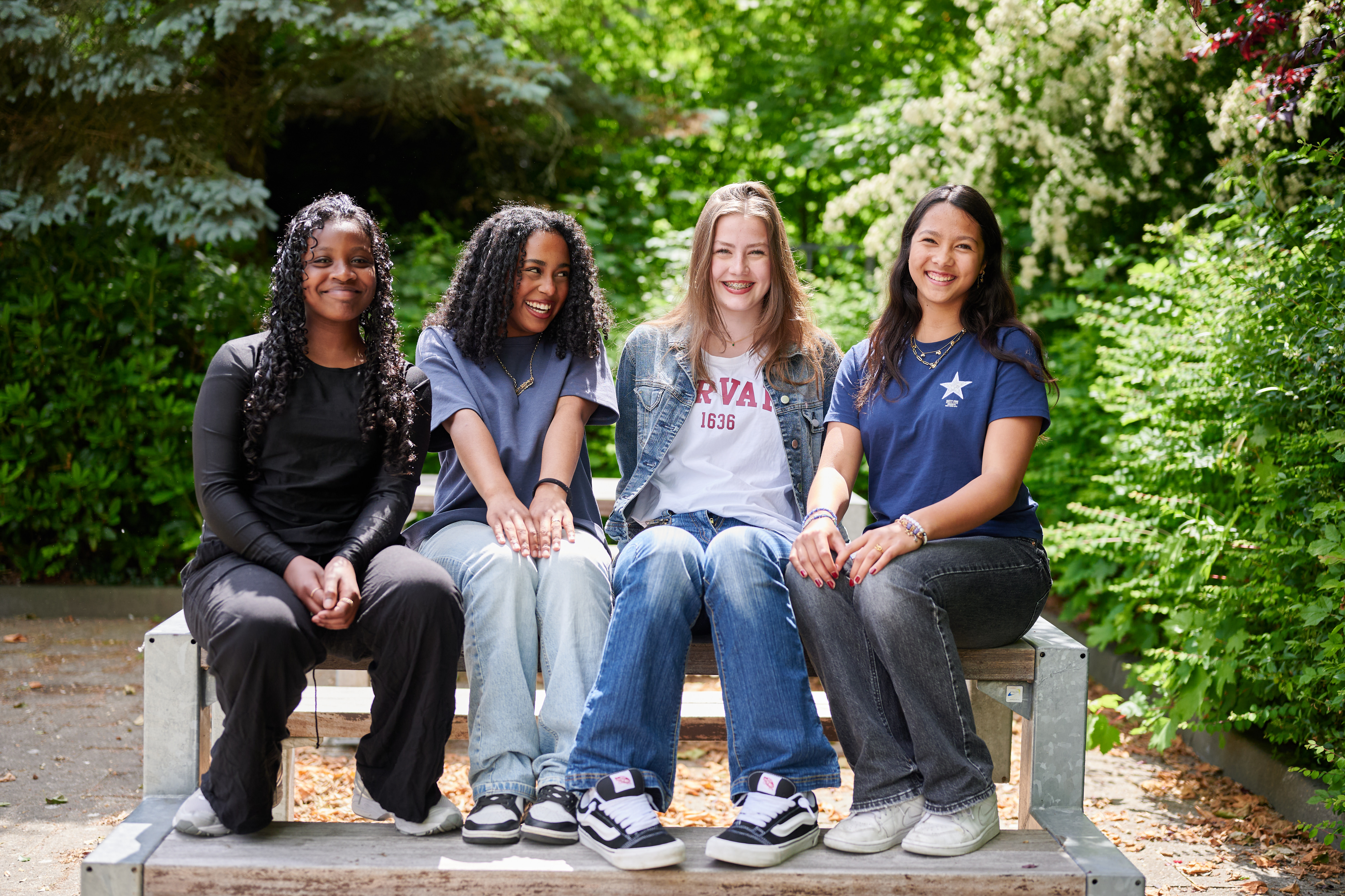 Vier leerlingen op een bankje op het schoolplein van een middelbare school