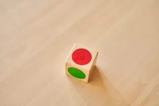 Dobbelsteen 'zelfstandig werken' met kleuren op bureau.