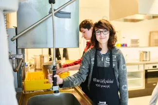VSO-leerling is bezig met afwas in kooklokaal.
